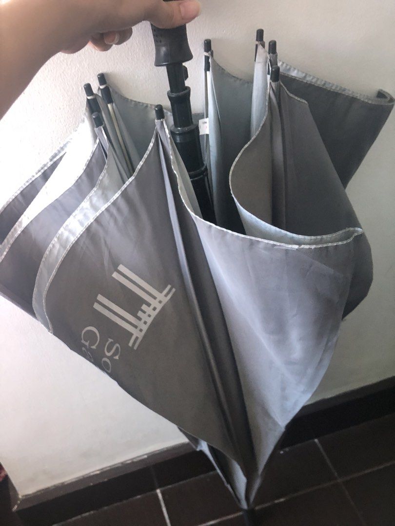 Golf Umbrella (Category: Umbrellas) located in Makati City. Submitted by danittt (Listing ID 1437056756, Image 2). Description: - Dark grey canopy - Black handle with textured grip - Light grey interior with 'South Gate' print - Includes a strap for secure closure Big umbrella type Bought this for 1k Selling for only 580.