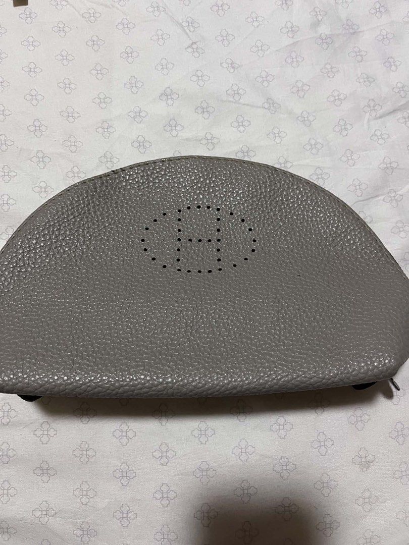 Hermes Clutch Bag (Category: Luxury Bags & Wallets) located in Manila. Submitted by jemerrysudlon16 (Listing ID 1437189754, Image 1). Description: - Gray clutch bag - Features Hermes logo - Zipper closure - Brown interior - Textured leather - Hermes logo on zipper pull.