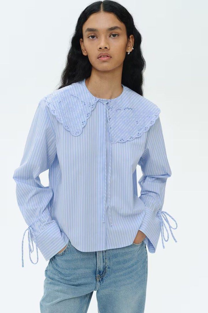 H&M Divided Striped Blouse with Collar [NEW] (Category: Blouses) located in Binan City. Submitted by thisisntninety (Listing ID 1437048149, Image 2). Description: - BRAND NEW - H&M Divided blouse - Light blue and white striped pattern - Unique collar with eyelet detailing - Long sleeves with tie cuffs - Tie closure at neckline.