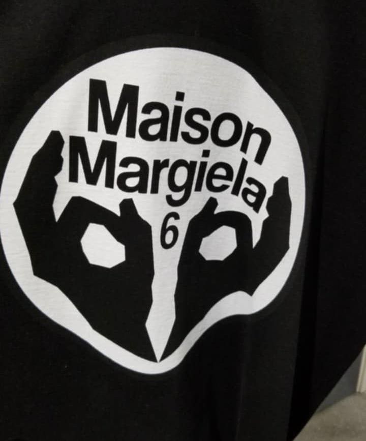 Maison Margiela 6 Graphic Tee (Category: Luxury Apparel) located in Navotas City. Submitted by ms.soulana (Listing ID 1437164425, Image 2). Description: PreOwned WellUsed Maison Margiela 6 graphic Printed t-shirt black Large -XL Width 23.5" -24" X L29" - Features a white circle graphic with the brand name and the number '6' - Classic crew neck design - Short sleeves - Made from cotton fabric Off/Legit. Cut tags Sign of Wear Good Condition 8.9/10 