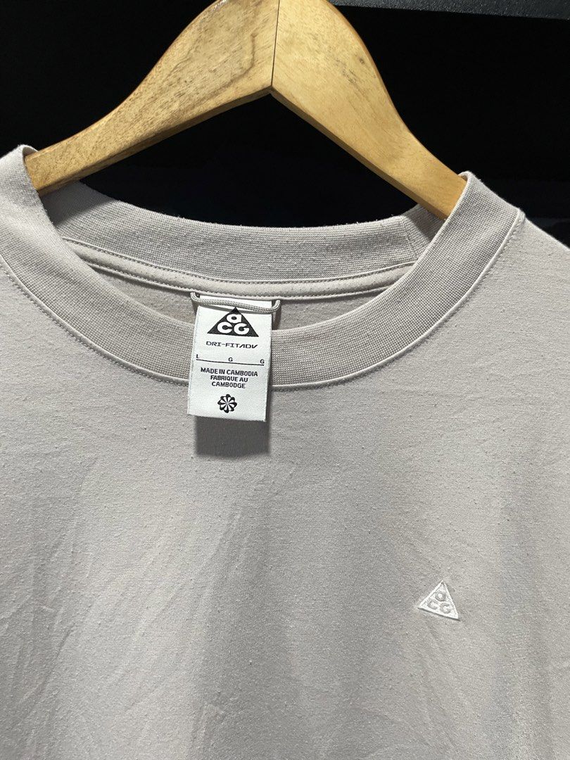 Nike Dri-Fit T-Shirt (Category: Activewear) located in Davao. Submitted by erwin_james (Listing ID 1437146761, Image 2). Description: - Nike collab with ACG Dri-Fit t-shirt - Light grey color - Size: Large - Features: Small Nike logo on chest, Dri-Fit technology - Made in Cambodia - Condition: Small hole or scratch on the side - Includes Goat Rocks tag - Dimension:21x27.