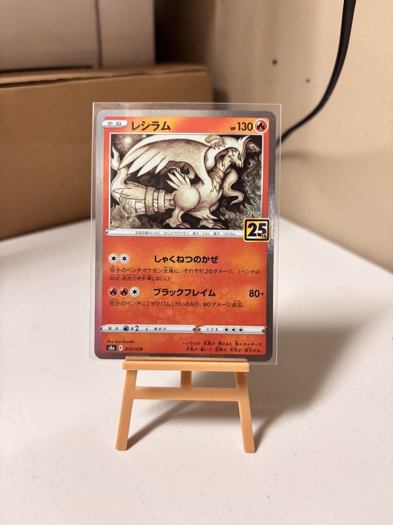 Pokemon Reshiram 25th Anniversary Card (Category: Raw Singles) located in Pasay City. Submitted by tindeclutterstuff (Listing ID 1437182977, Image 1). Description: - Pokemon Reshiram card - From the 25th Anniversary collection - Features detailed Reshiram illustration - Japanese text - Comes in a protective sleeve - Card displayed on a small easel - Comes with a protective sleeve #pokemon #pokemoncards #cards #tcg .