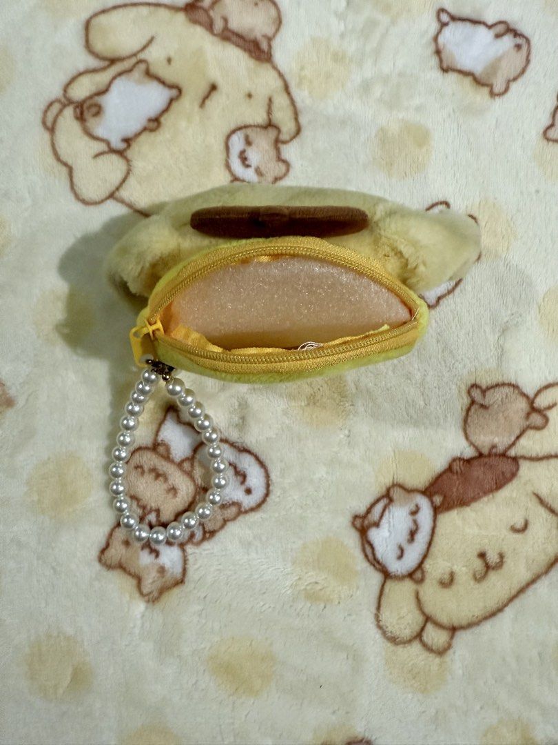 Pompompurin Plush Keychain coin purse (Category: Character Goods) located in Taguig. Submitted by karabelle19923 (Listing ID 1437025570, Image 2). Description: - not official Adorable Pompompurin plush keychain coin purse - Includes a small zippered compartment - Comes with a stylish pearl beaded strap - Perfect for keys, bags, or as an accessory - Features a yellow plush with a brown hat and embroidered facial features.