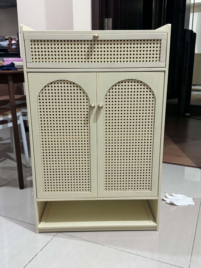Rattan Style Shoe Cabinet (Category: Everything Else Others) located in Manila. Submitted by jezm. (Listing ID 1437186661, Image 1). Description: - Rattan-style shoe cabinet - Two doors - Multiple shelves for shoe storage - Top drawer - Open bottom shelf - Light cream color - Made of wood or similar material.
