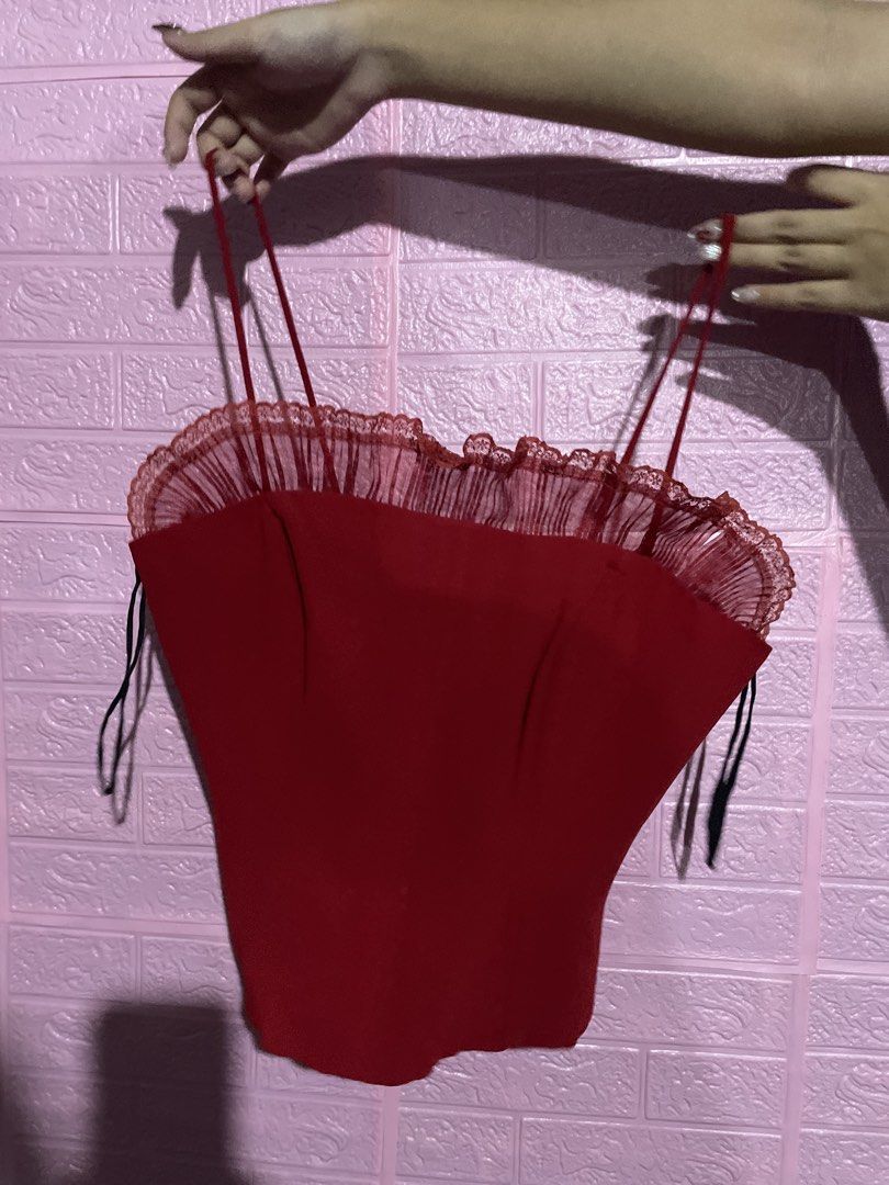 Red Corset Top with Ruffle Detail (Category: Sleeveless) located in Quezon City. Submitted by radiusmile (Listing ID 1437113489, Image 3). Description: - Red corset top - Spaghetti straps - Ruffle neckline detail - Fitted silhouette - Back zipper closure - Vibrant red color - Smooth, satin-like material.