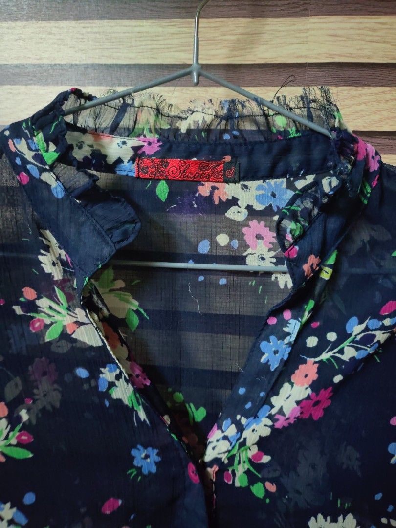 Shapes Floral Navy Blue Blouse (Category: Blouses) located in Makati City. Submitted by mybentables (Listing ID 1437158054, Image 2). Description: - Navy blue blouse - Floral pattern - V-neck design - Short sleeves - Sheer fabric - Tag visible in photos -Fits medium to large.