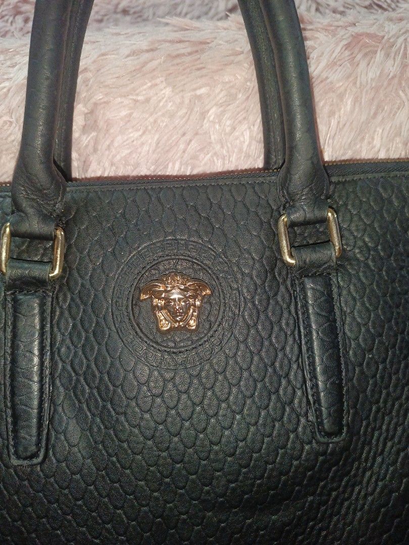 Versace Black Leather Handbag (Category: Luxury Bags & Wallets) located in Rizal. Submitted by judithtillo19 (Listing ID 1437140037, Image 2). Description: - Black leather handbag - Textured finish - Gold-tone Versace Medusa head emblem - Dual top handles - Zip closure with gold-tone pull - Detachable shoulder strap DOCUMENT,OFFICE , LAPTOP BAG CAN FIT 12 TO 14" LAPTOP YKK ZIPPER ( POCKET INSIDE) EDGES ARE STILL GOOD GENUINE LEATHER PRELOVED BUT 