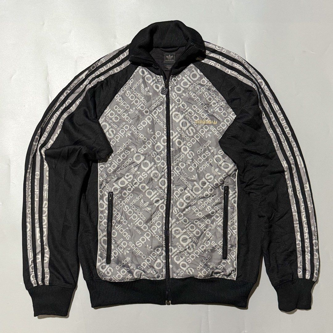 Adidas Track Jacket with Logo Print (Category: Coats, Jackets and Outerwear) located in Zamboanga. Submitted by arganhadjula28 (Listing ID 1437266128, Image 1). Description: - Adidas track jacket - Repeating logo pattern on front panel - Full zip closure - Side pockets - Iconic three stripes on sleeves - Ribbed collar and cuffs - Adidas logo on chest and zipper.