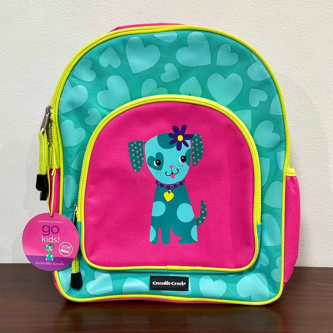 [Authentic] Crocodile Creek Go Kids Dog Backpack (Category: Babies & Kids Fashion) located in Quezon City. Submitted by brandedusagoodies (Listing ID 1437386933, Image 1). Description: Adorable Crocodile Creek kid-sized backpack featuring a cute puppy character design with colorful heart patterns and bright contrast details. Lightweight and practical for school, daycare, travel, or everyday essentials for kids. Material – Polyester Fabric Color /