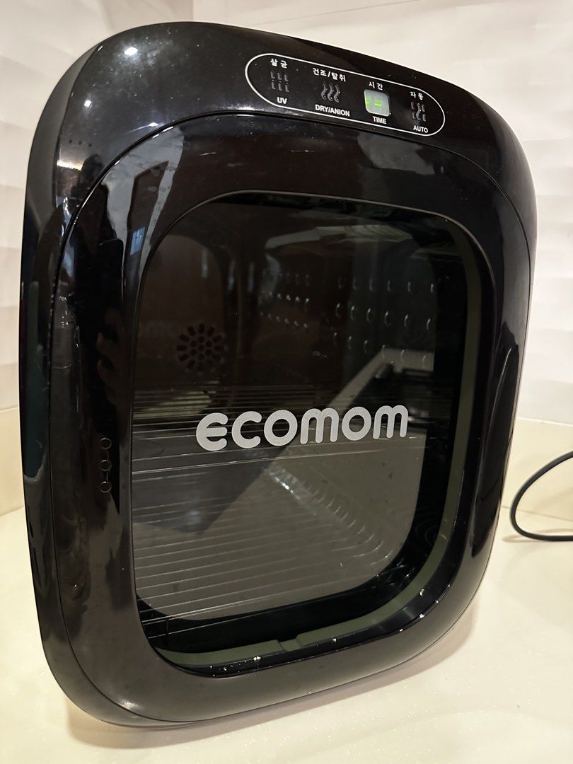Ecomom 100 UV Sterilizer (Category: Breastfeeding & Bottle Feeding) located in Muntinlupa City. Submitted by shopnb (Listing ID 1437251937, Image 1). Description: - Ecomom UV sterilizer with drying function. - Features: UV sterilization, drying, and anion functions. - Settings: Time and Auto modes. - Design: Black and white with a clear door. - Includes: Internal rack for items. - Control Panel: Located on top..