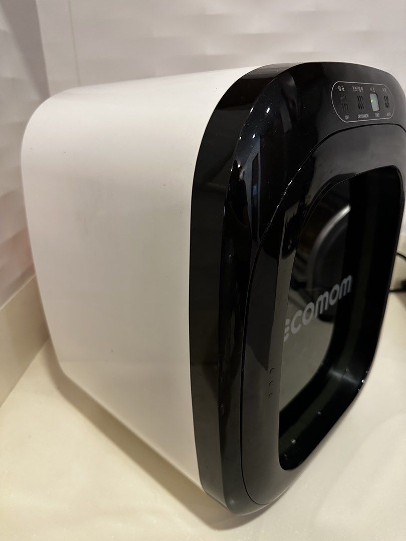 Ecomom 100 UV Sterilizer (Category: Breastfeeding & Bottle Feeding) located in Muntinlupa City. Submitted by shopnb (Listing ID 1437251937, Image 2). Description: - Ecomom UV sterilizer with drying function. - Features: UV sterilization, drying, and anion functions. - Settings: Time and Auto modes. - Design: Black and white with a clear door. - Includes: Internal rack for items. - Control Panel: Located on top..