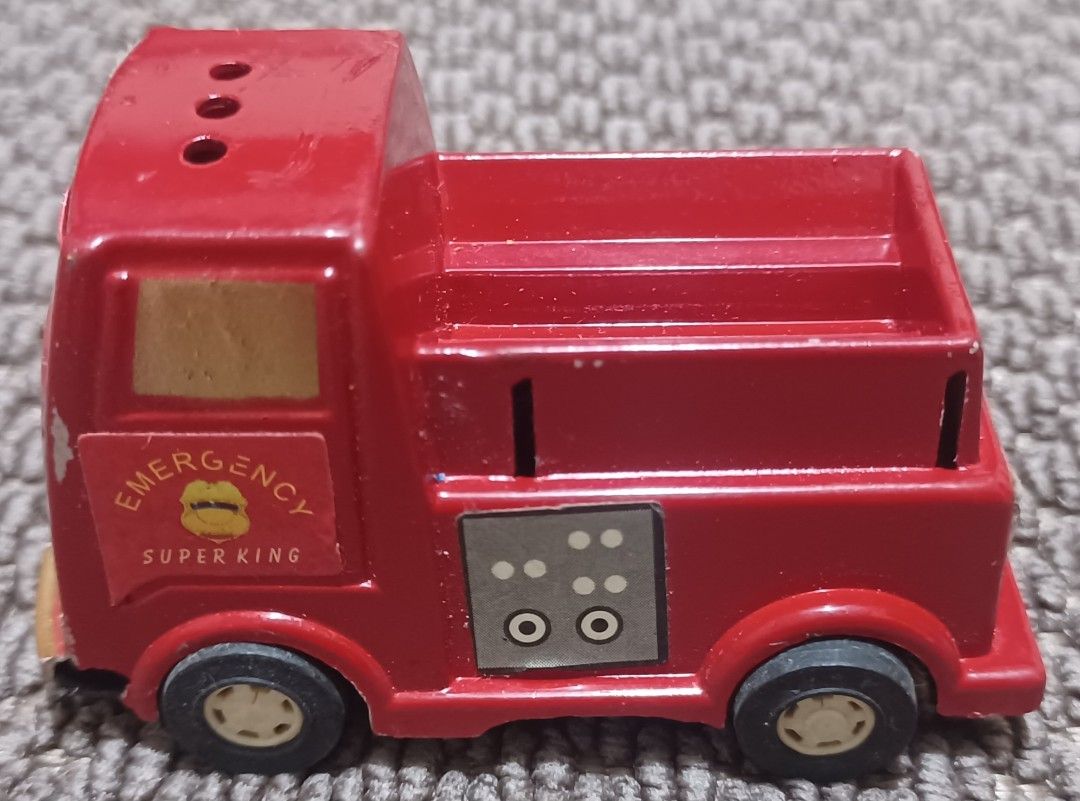 Emergency Super King Toy Truck (Category: Vehicle & Diecast Models) located in Quezon City. Submitted by wjmae (Listing ID 1437286757, Image 3). Description: - Red toy truck - Features 'Emergency Super King' text - Smiling face design - Truck bed in the back - Black wheels - Vintage toy - Shows wear and tear.