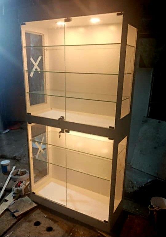 Glass Display Cabinet with Lights (Category: Shelves, Cabinets & Racks) located in Manila. Submitted by ronav25916562 (Listing ID 1437306499, Image 2). Description: - Elegant glass display cabinet - Two sections with multiple shelves - Built-in lighting - White frame - Glass doors - Includes a lock - Ideal for collectibles and valuables - Suitable for home or retail Made to order.