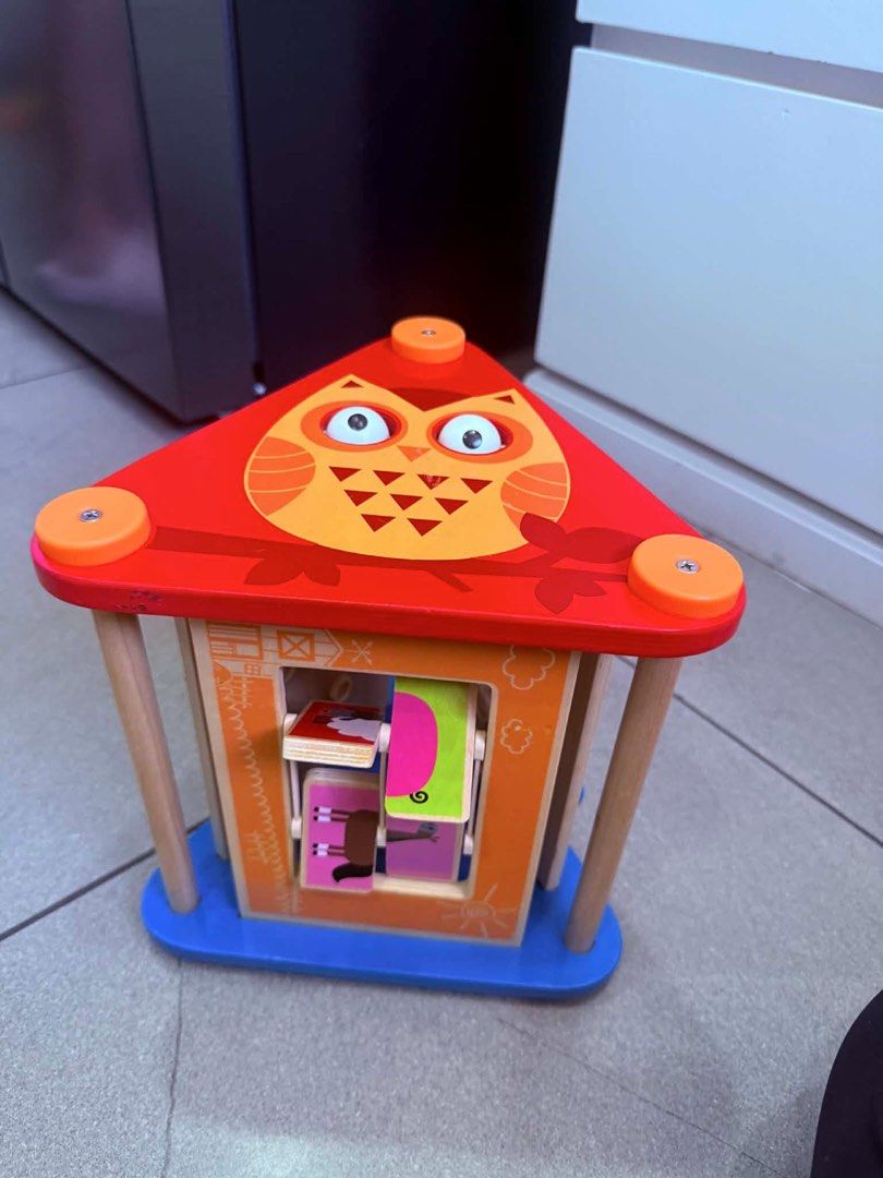 Hape Take-Along Activity Box (Category: Infant Playtime) located in Makati City. Submitted by eyes_jade (Listing ID 1437284369, Image 2). Description: - Hape wooden activity cube - Multiple sides with different activities - Includes gears with animal designs - Features a rotating puzzle - Made of wood - Colorful design - Designed for young children.
