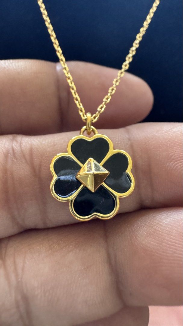 Kate Spade Flower Pendant Necklace (Category: Necklaces) located in Santa Cruz. Submitted by maqui15 (Listing ID 1437397958, Image 2). Description: - Kate Spade necklace - Delicate gold chain - Flower pendant with black enamel and gold border - Features a small gem in the center - Adjustable length - Spade charm near the clasp - Includes Kate Spade dust bag.