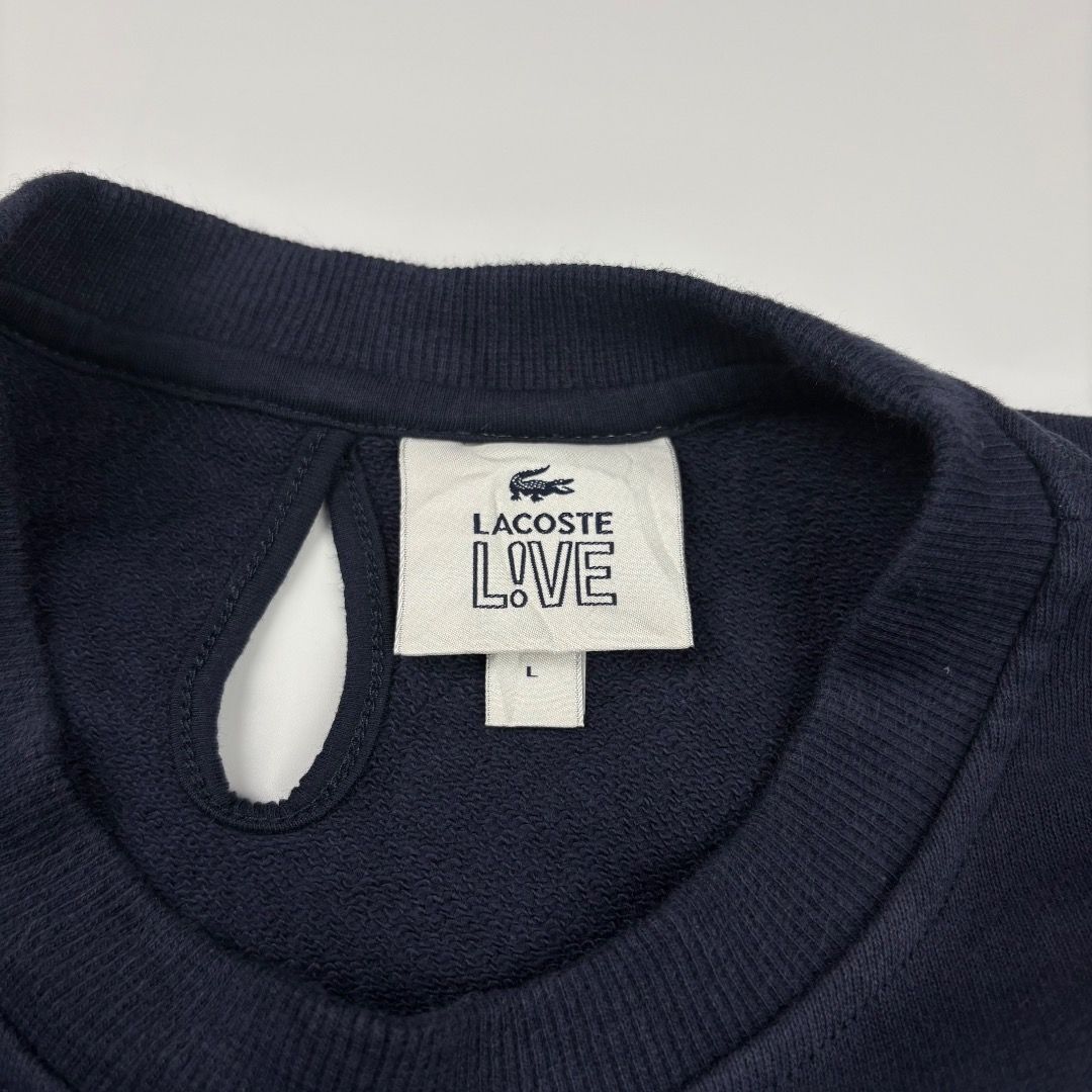 Lacoste Live VE Navy Blue Sweatshirt (Category: Coats, Jackets and Outerwear) located in Enrique B. Magalona (Saravia). Submitted by artisan.ph (Listing ID 1437353088, Image 3). Description: - Lacoste L!VE sweatshirt in navy blue. - Size: L - Features the iconic Lacoste crocodile logo. - Classic crew neck design. - Long sleeves. - Includes a small white tag on the sleeve cuff. - Inside tag with Lacoste L!VE branding and size information..