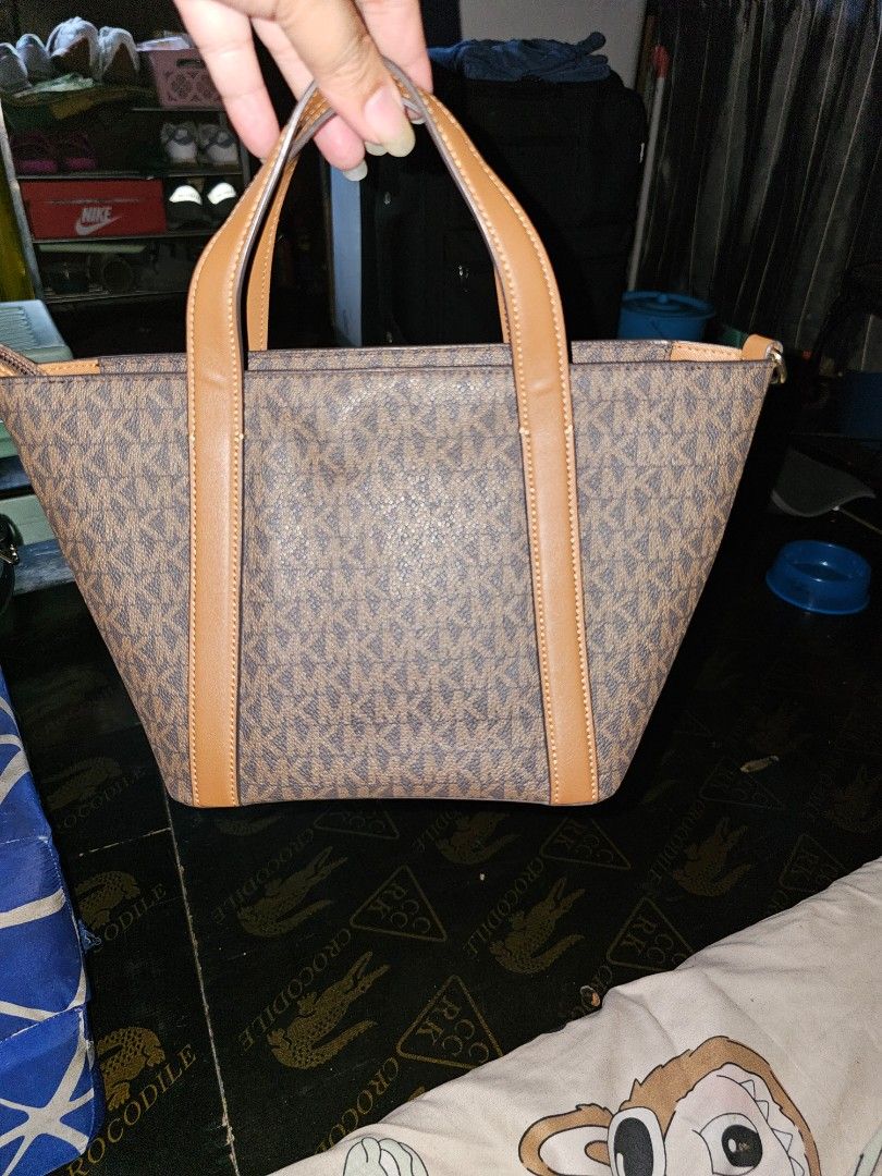 Michael Kors Tote Bag (Category: Luxury Bags & Wallets) located in Malabon City. Submitted by jhimilicious (Listing ID 1437220212, Image 2). Description: - Michael Kors tote bag - Brown monogram pattern - Tan leather accents - Top zipper closure - Interior pocket - Detachable shoulder strap - Gold-tone MK logo - Includes silica gel packet.