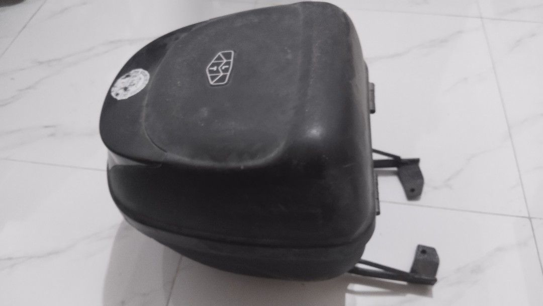 Motorcycle Top Box with Mounting Bracket (Category: Other Motorcycles Parts and Accessories) located in Manila. Submitted by findingneutral (Listing ID 1437236518, Image 1). Description: - Durable motorcycle top box - Provides extra storage space - Features a secure locking mechanism - Includes mounting bracket for easy installation - Sleek black finish - Visible logo on top - Designed for motorcycle use - Mounts on the rear of the motorcycle.