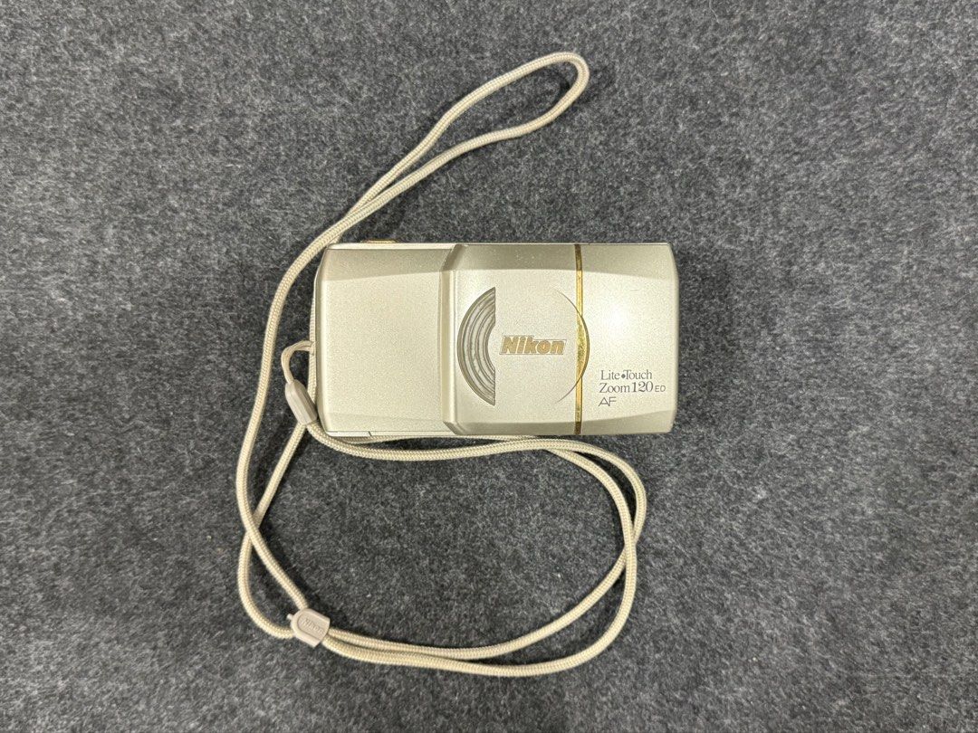 Nikon Lite Touch Zoom 120 ED AF Film Camera (Category: Cameras) located in Manila. Submitted by qygn94zbr737519 (Listing ID 1437324474, Image 1). Description: - Nikon Lite Touch Zoom 120 ED AF film camera - Silver camera body - Built-in zoom lens - Includes beige strap - Model name printed on front.