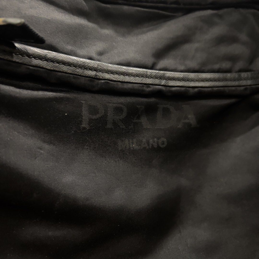 Prada Messenger Bag (Category: Luxury Bags & Wallets) located in Paranaque City. Submitted by btslite (Listing ID 1437382215, Image 2). Description: - Issue on main zipper, has a hole - Dimension (12x10 inches) - Prada messenger bag - Color: Black - Features: - Main compartment - Interior pocket - Shoulder strap - Zipper closure - Prada logo visible on front - Prada logo pattern on interior lining ⚠️ Condition: Pre-loved / second-hand. Not brand 