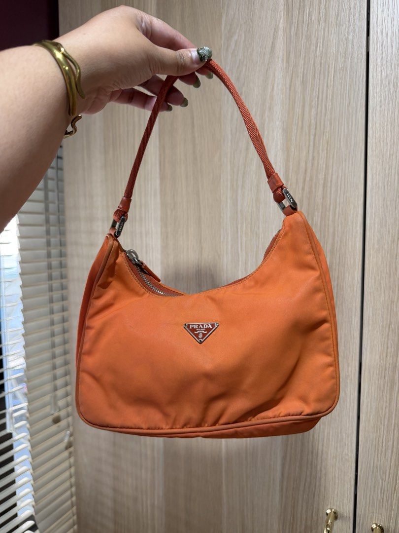 Prada Orange Nylon Bag (Category: Luxury Bags & Wallets) located in San Juan City. Submitted by girlmaths (Listing ID 1437301041, Image 3). Description: - bought from trusted vintage shop: @bagnginamo - Condition: well used - few dirt marks but can be washed. This was sent to a bag spa, inner lining was re-stitched, and bag was cleaned. - RFS: decluttering - Price negotiable .