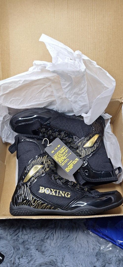 RB Boxing Shoes Black size 37 (Category: Combat Sports) located in Manila. Submitted by chavezmade78698 (Listing ID 1437365116, Image 1). Description: - Black boxing shoes with gold accents - Features "RB" brand logo - "BOXING" text visible on the side - Shiny, patent leather-like toe and heel - Includes original box and tissue paper.