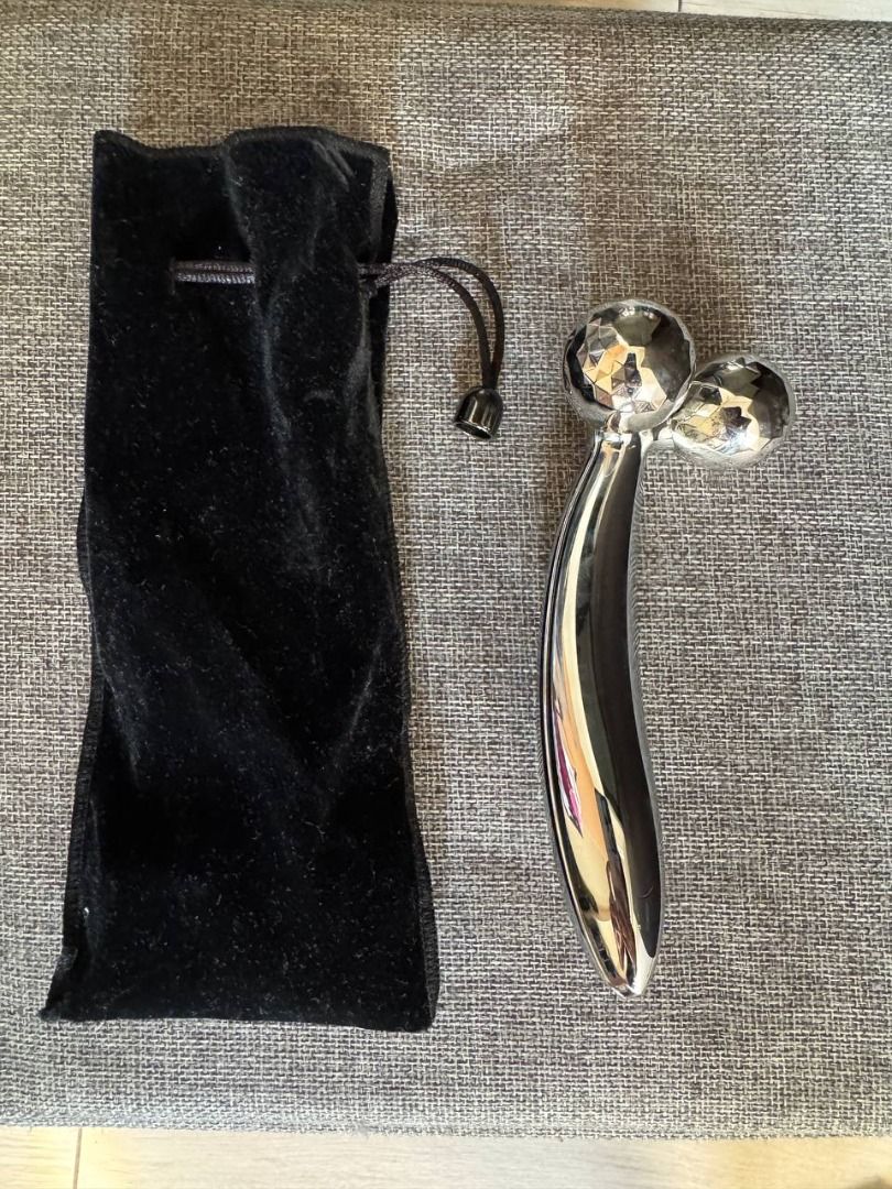 ReFa CARAT FACE Double Roller Facial Massager (Category: Face Care) located in Makati City. Submitted by swiftwind_fd3653 (Listing ID 1437284856, Image 1). Description: - Features two textured, faceted spheres. - Ergonomic, smooth handle. - Made of a shiny, metallic material. - Comes with a black velvet pouch for storage..