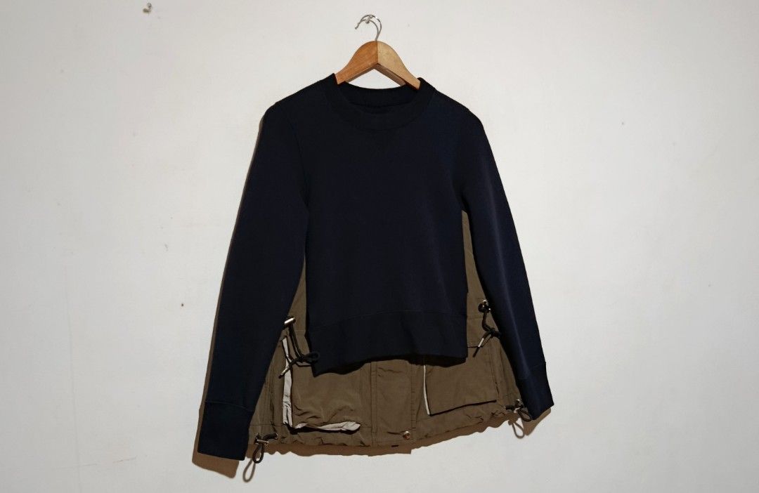 Sacai - Docking Sweatshirt Utility Drawstring - Navy Blue/Khaki (Category: Coats, Jackets and Outerwear) located in San Fernando. Submitted by son.twice.stuff (Listing ID 1437357156, Image 2). Description: Item: Sacai - Docking Sweatshirt Utility Drawstring - Navy Blue/Khaki Tagged Size: 1 Fit Medium Dimensions Length: 26" Width: 18" Shoulder: 15" Sleeve: 24" Condition: Excellent Zipper: YKk VISLON Puller: SACAI Made in Japan Material 62% Cotton 