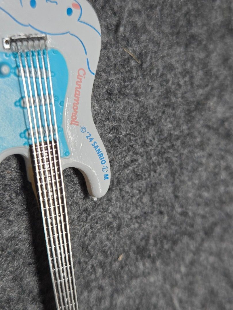 Sanrio Cinnamoroll Guitar and Amplifier Set (mini figures) (Category: Musical Instruments) located in Manila. Submitted by joycee03 (Listing ID 1437240778, Image 3). Description: - Cinnamoroll guitar and amplifier set - Features a blue and white design with Cinnamoroll graphics - Includes matching amplifier and guitar stand - Sanrio logo present - Ideal for collectors and Sanrio enthusiasts.