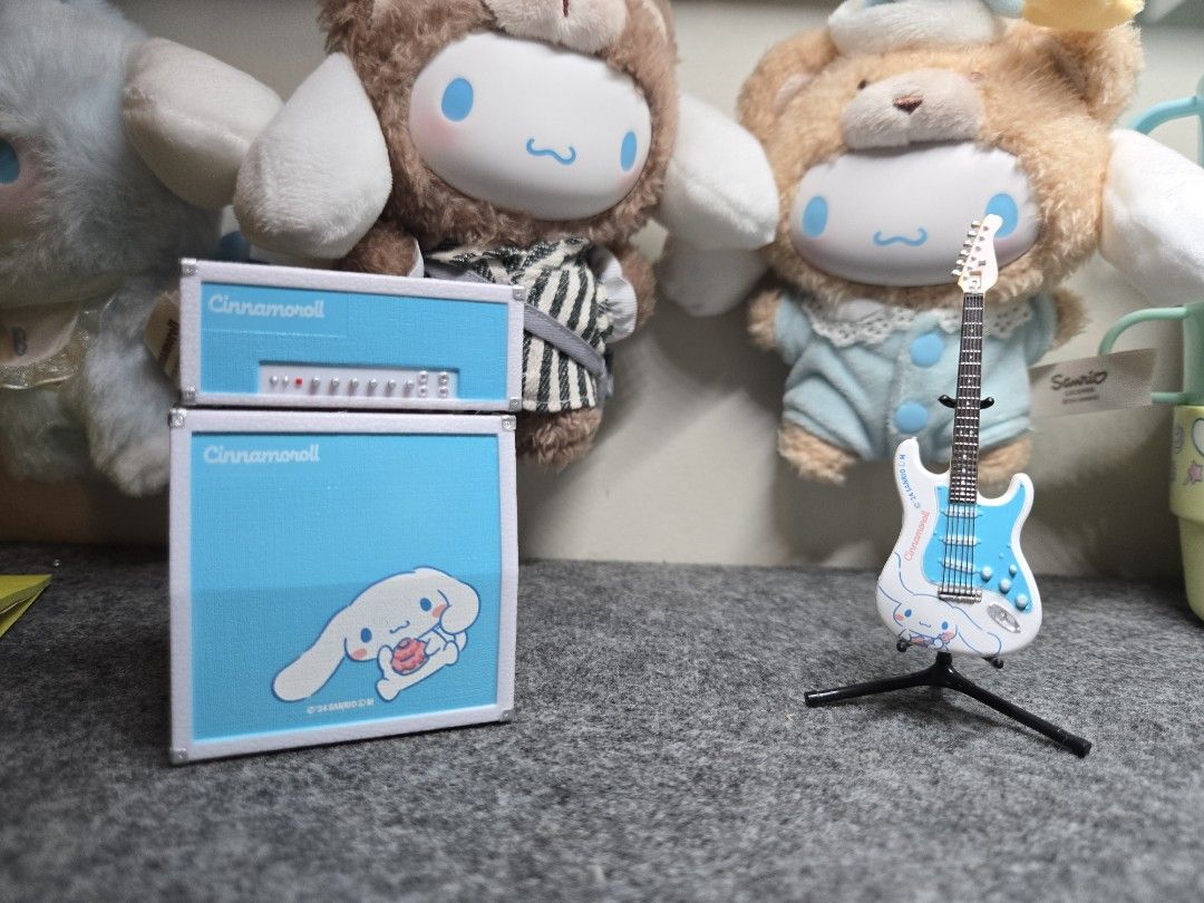 Sanrio Cinnamoroll Guitar and Amplifier Set (mini figures) (Category: Musical Instruments) located in Manila. Submitted by joycee03 (Listing ID 1437240778, Image 1). Description: - Cinnamoroll guitar and amplifier set - Features a blue and white design with Cinnamoroll graphics - Includes matching amplifier and guitar stand - Sanrio logo present - Ideal for collectors and Sanrio enthusiasts.