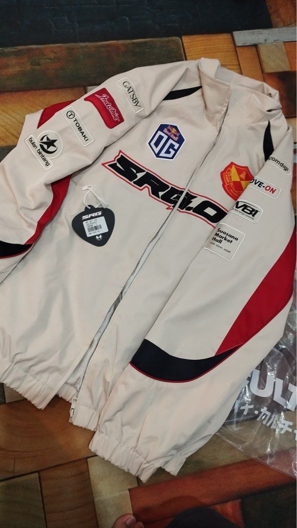 SRG Jacket (Category: Coats, Jackets and Outerwear) located in Kuala Lumpur. Submitted by amirinmorn28246 (Listing ID 1437366227, Image 1). Description: - SRG racing jacket - Color: Cream with red and black accents - Features patches: "OG", "GATSBY", "MOVE-ON" - Size: L - Full zipper closure - Includes "HIGH CULTURED PLAYAZ" label inside.