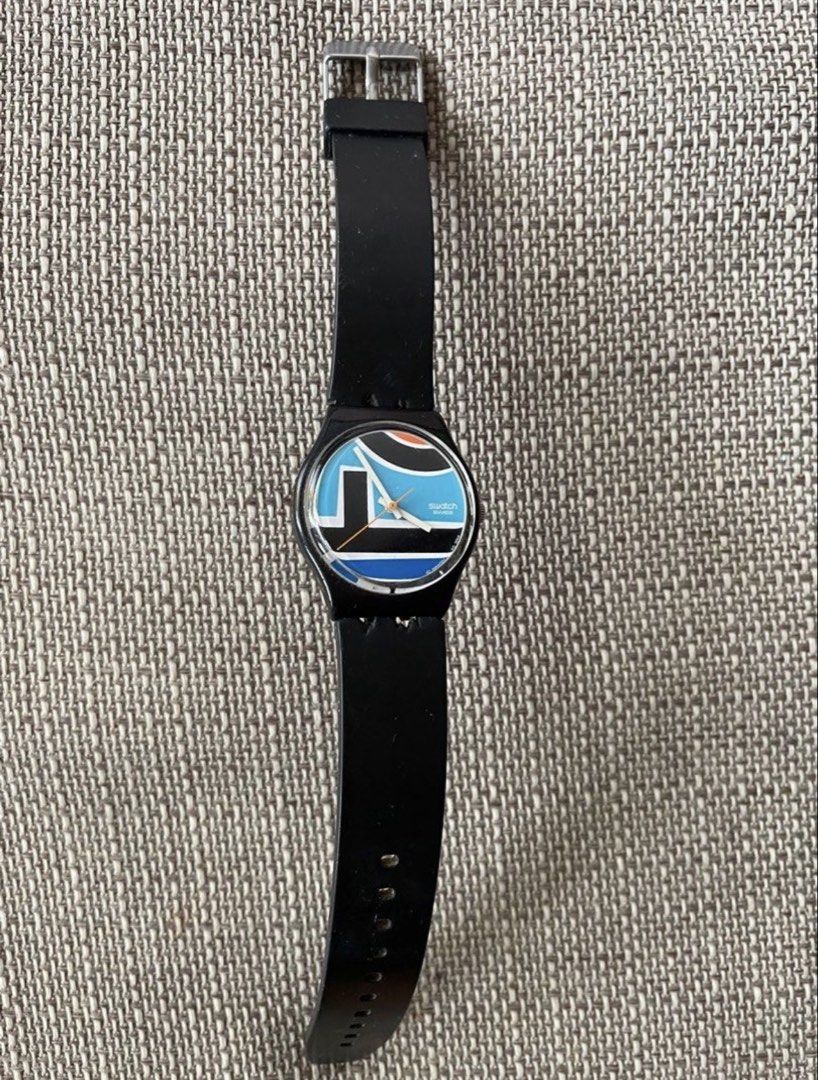 SWATCH Watch with Black Strap (Category: Women's Watches) located in Pasig City. Submitted by khaleisi (Listing ID 1437395064, Image 1). Description: - Swatch watch with a stylish black strap. - Eye-catching dial design with blue, white, and black elements. - Durable black case. - Secure silver buckle. - Textured strap material. - Authentic Swatch branding on the watch back. - Not original strap - With battery.