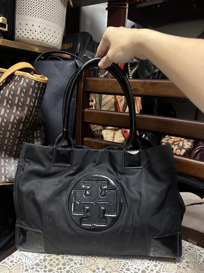 Tory Burch Black Nylon Tote Bag (Category: Luxury Bags & Wallets) located in Lucena. Submitted by blush_lux (Listing ID 1437277357, Image 1). Description: - Tory Burch black nylon tote bag - Large logo on the front - Patent leather accents - Two top handles - Stylish and practical for everyday use.