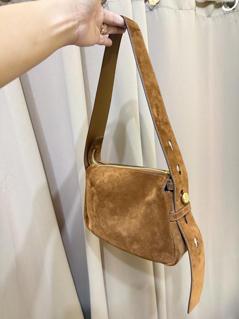 Tory Burch Suede Shoulder Bag (Category: Luxury Bags & Wallets) located in Bato. Submitted by babylaarni26255 (Listing ID 1437258474, Image 3). Description: - Tory Burch shoulder bag - Brown suede exterior - Leather shoulder strap - Gold-toned zipper and hardware - Interior pocket with Tory Burch logo - Rectangular shape.