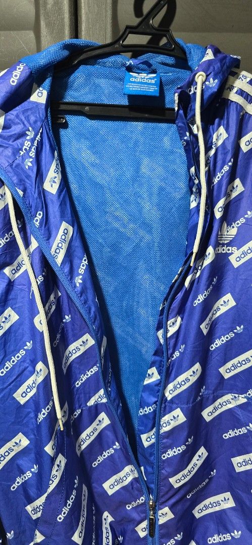 Adidas Windbreaker Jacket (Category: Coats, Jackets and Outerwear) located in Manila. Submitted by muliph (Listing ID 1437561175, Image 2). Description: - Adidas windbreaker jacket - Blue with all-over logo print - Full zip closure - Hood with drawstrings - White stripes on sleeves - Blue mesh lining - Adidas logo details.