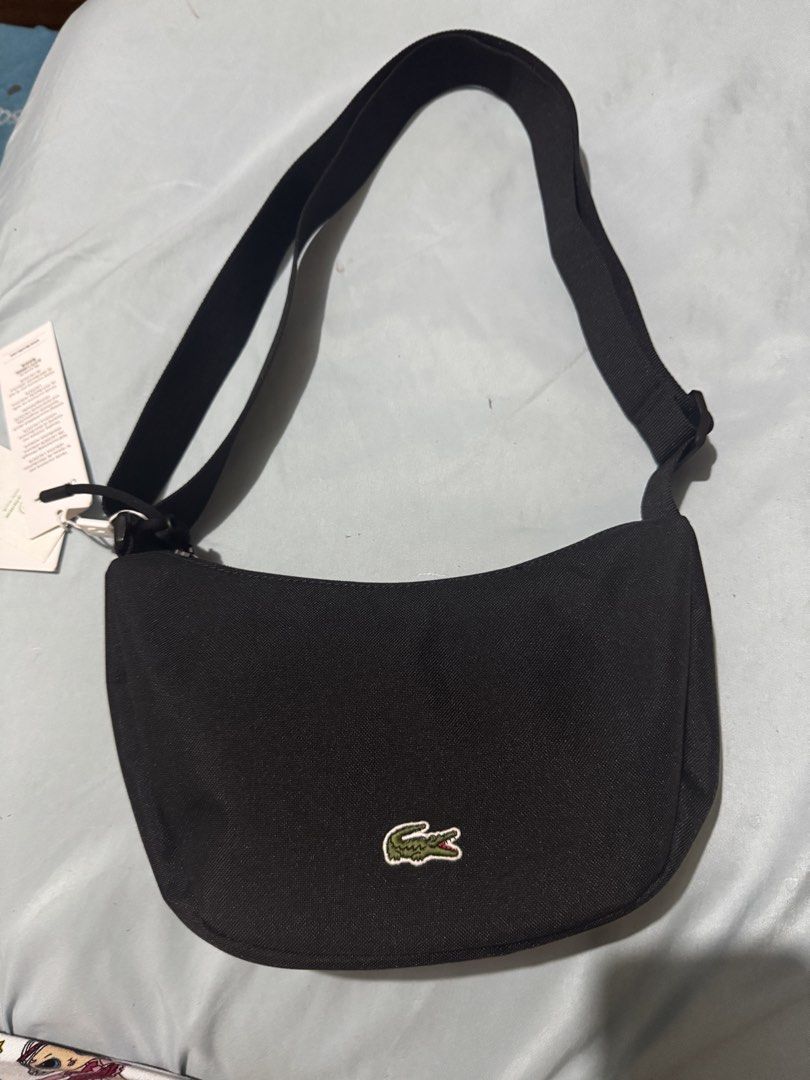 AUTHENTIC Lacoste Moon Bag - Black (Category: Luxury Bags & Wallets) located in Makati City. Submitted by makayshoppe (Listing ID 1437525256, Image 1). Description: Authentic Lacoste moon bag in black polyester. Purchased from DutyFree Philippines. Shipping c/o buyer. .