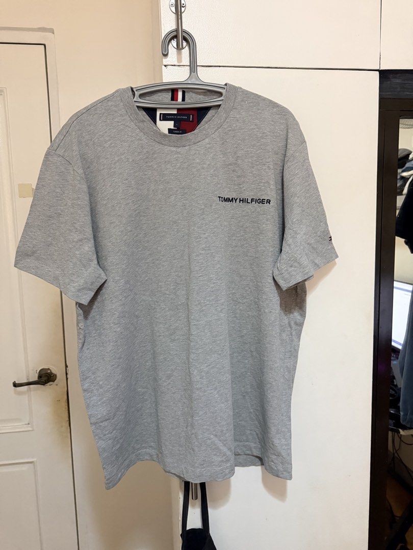 (Authentic) Tommy Hilfiger TH Classic Shirt (Category: Tshirts & Polo Shirts ) located in Cavite. Submitted by kumbin (Listing ID 1437414297, Image 3). Description: Tommy Hilfiger Embroidered Classic Shirt (legit/authentic) Color: Heather grey with embroidery 🩶 Fabric: Soft, heavy cotton Dimensions: 24 by 29 inches (L on tag, fits up to XL) Issue: Dot mending (see last pic, barely noticeable), and removed wash tags. Other than that, brand new co