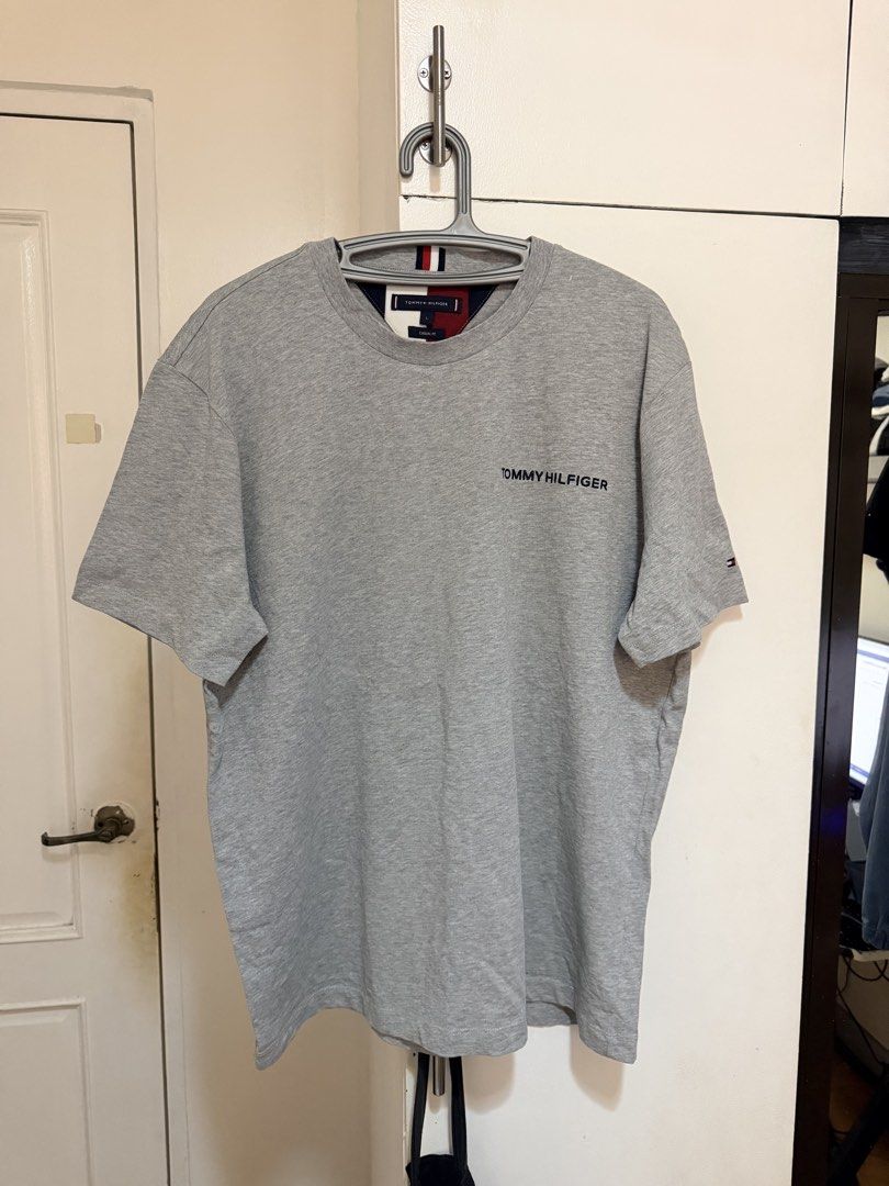 (Authentic) Tommy Hilfiger TH Classic Shirt (Category: Tshirts & Polo Shirts ) located in Cavite. Submitted by kumbin (Listing ID 1437414297, Image 2). Description: Tommy Hilfiger Embroidered Classic Shirt (legit/authentic) Color: Heather grey with embroidery 🩶 Fabric: Soft, heavy cotton Dimensions: 24 by 29 inches (L on tag, fits up to XL) Issue: Dot mending (see last pic, barely noticeable), and removed wash tags. Other than that, brand new co