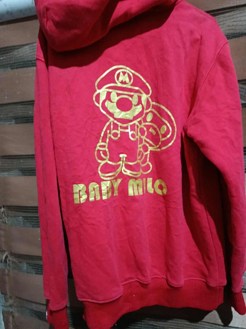 Baby Milo Mario Hoodie (Category: Hoodies) located in Bolinao. Submitted by willaskyle19427 (Listing ID 1437420918, Image 2). Description: - Red hoodie with a large Mario design on the front. - Features a Baby Milo Mario graphic on the back. - Full zip closure. - Hood designed like a Mario hat. - Made of soft material. - Includes a kangaroo pocket. issue - not working zipper need repair.