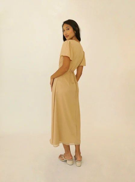Beige Midi Dress (Category: Dresses) located in Muntinlupa City. Submitted by em_prelovedx (Listing ID 1437545909, Image 2). Description: - Beige midi dress - V-neckline - Flutter sleeves - Flared skirt - Tie-back detail for adjustable fit - Perfect for special occasions .
