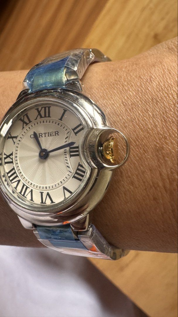 Cartier Ballon Bleu Watch (Category: Luxury Watches) located in Alfonso Lista (Potia). Submitted by mightyowl.270 (Listing ID 1437462553, Image 2). Description: - Cartier Ballon Bleu watch - Silver dial with Roman numeral hour markers - Stainless steel bracelet with gold-tone accents - Distinctive crown design - Shown on wrist for size reference *Generic Box Only .