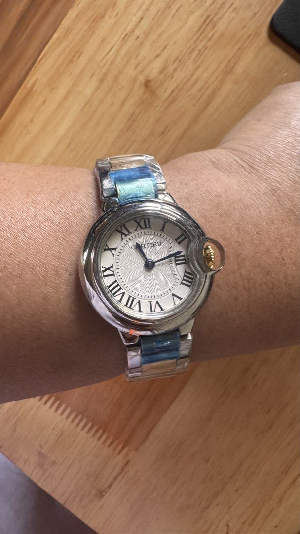 Cartier Ballon Bleu Watch (Category: Luxury Watches) located in Alfonso Lista (Potia). Submitted by mightyowl.270 (Listing ID 1437462553, Image 1). Description: - Cartier Ballon Bleu watch - Silver dial with Roman numeral hour markers - Stainless steel bracelet with gold-tone accents - Distinctive crown design - Shown on wrist for size reference *Generic Box Only .