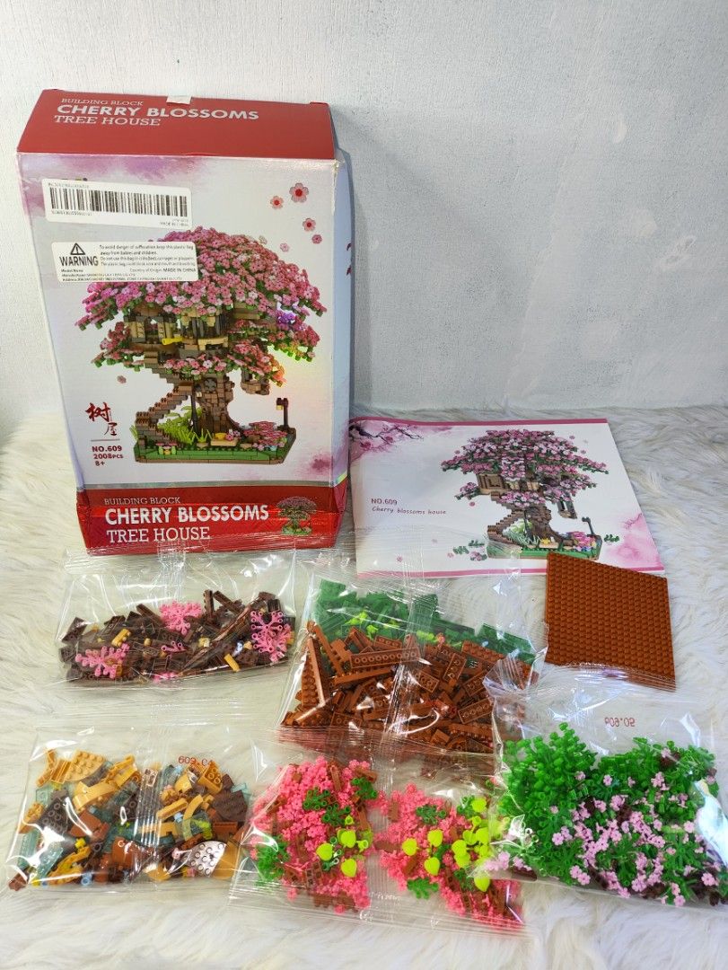 Cherry Blossoms Tree House Building Block Set (Category: Toys & Games) located in Cavite. Submitted by tinetaclesss (Listing ID 1437444386, Image 1). Description: - Cherry Blossoms Tree House building block set. - Includes various colored blocks. - Comes with a detailed instruction manual. - Multiple sealed bags of blocks included (all pieces present). - Complete set, ready for assembly. - Box shows the finished model..