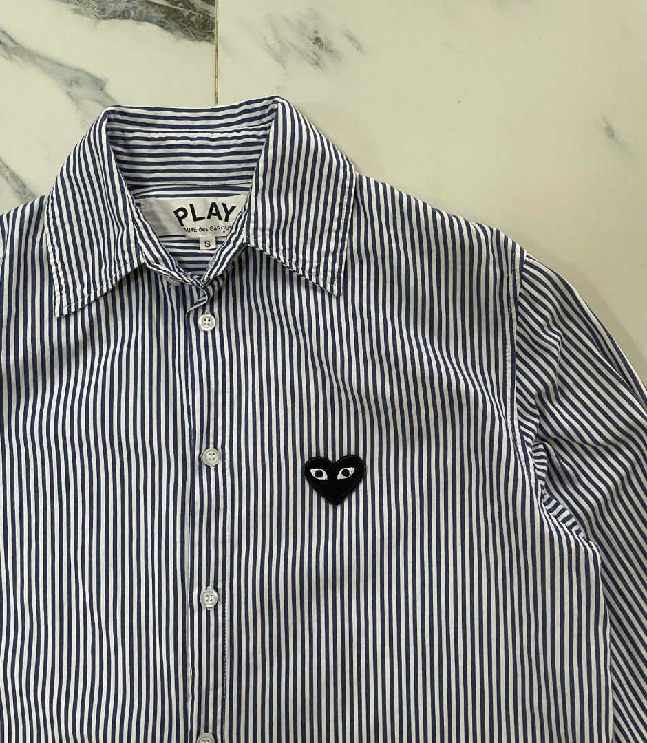 Comme des Garcons Play Striped Shirt (Category: Shirts) located in Caloocan City. Submitted by maitumroye57862 (Listing ID 1437431840, Image 3). Description: - Comme des Garcons Play shirt - Size: S - Features the iconic heart logo - Striped pattern (blue and white) - Classic collar and button-down - Long sleeves - Made in Japan.