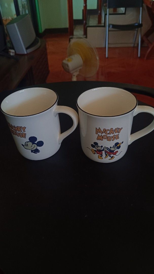 Corelle Mickey Mouse Mug (Category: Coffee & Tea Tableware) located in Taguig. Submitted by redarmy21775000 (Listing ID 1437414890, Image 2). Description: - Set of two Corelle mugs - Features Mickey Mouse design - White base with black rim - Includes handles for easy gripping - Corelle logo visible - Ideal for coffee, tea, and other beverages.