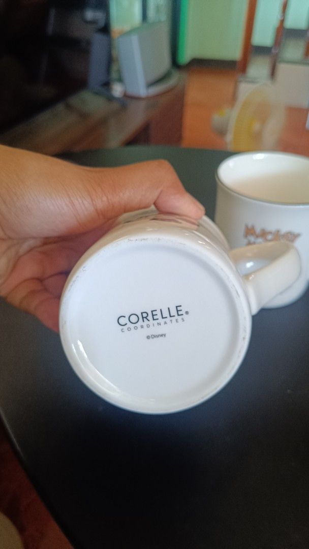 Corelle Mickey Mouse Mug (Category: Coffee & Tea Tableware) located in Taguig. Submitted by redarmy21775000 (Listing ID 1437414890, Image 3). Description: - Set of two Corelle mugs - Features Mickey Mouse design - White base with black rim - Includes handles for easy gripping - Corelle logo visible - Ideal for coffee, tea, and other beverages.