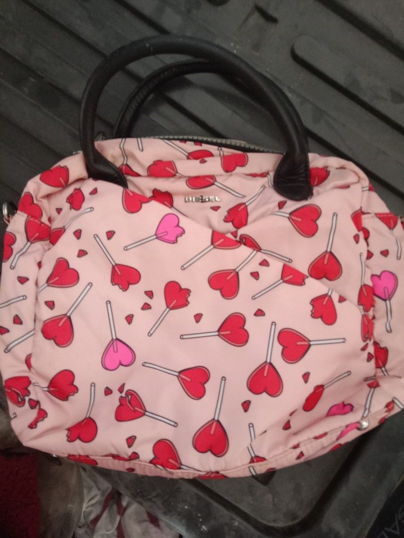 Diesel Heart Print Handbag (Category: Luxury Bags & Wallets) located in Bulacan. Submitted by chubbylicious (Listing ID 1437512651, Image 1). Description: - Diesel handbag with a fun heart print. - Features a top handle and a secure zip closure. - Includes a detachable shoulder strap. - Interior is black with a small pocket. - Authentic Diesel logo visible inside..