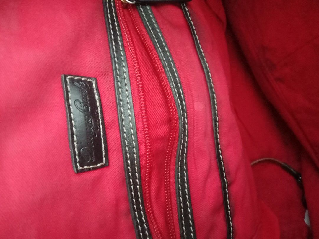 Dooney & Bourke DB Handbag (Category: Luxury Bags & Wallets) located in Bulacan. Submitted by chubbylicious (Listing ID 1437512310, Image 3). Description: - Authentic Dooney & Bourke handbag - Beige exterior with DB logo pattern - Black accents on handles and corners - Red interior - Multiple zippered compartments - Top zipper closure - Includes leather tag inside .