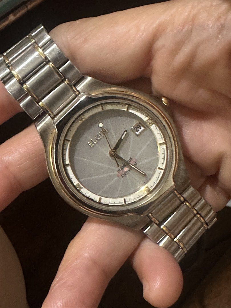 Elgin Quartz Watch (Category: Women's Watches) located in Manila. Submitted by roseluxuryitems (Listing ID 1437457487, Image 3). Description: - Elgin watch with silver dial and gold accents - Date display - Stainless steel band with gold-colored links - "ELGIN USA" clasp - Quartz movement - Textured dial - Detailed emblem on the back.