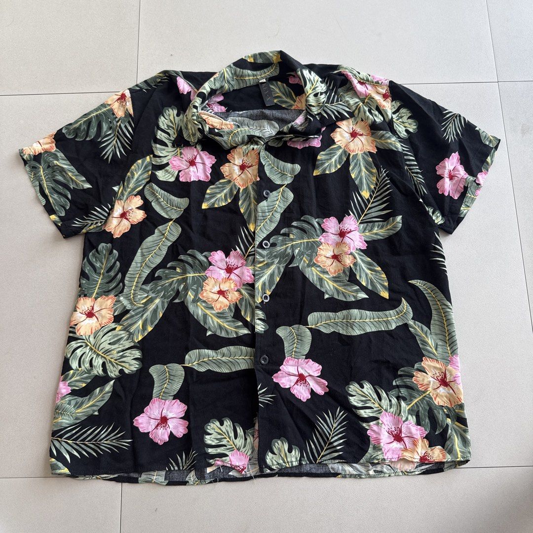 Floral Hibiscus Print Beach Shirt (Category: Shirts) located in Cebu City. Submitted by strawbeanz (Listing ID 1437464549, Image 1). Description: - Short sleeve shirt - Vibrant floral print - Button-down front - Classic collar - Colors: Pink, orange, white flowers with green leaves - Lightweight fabric - Ideal for casual, tropical wear.